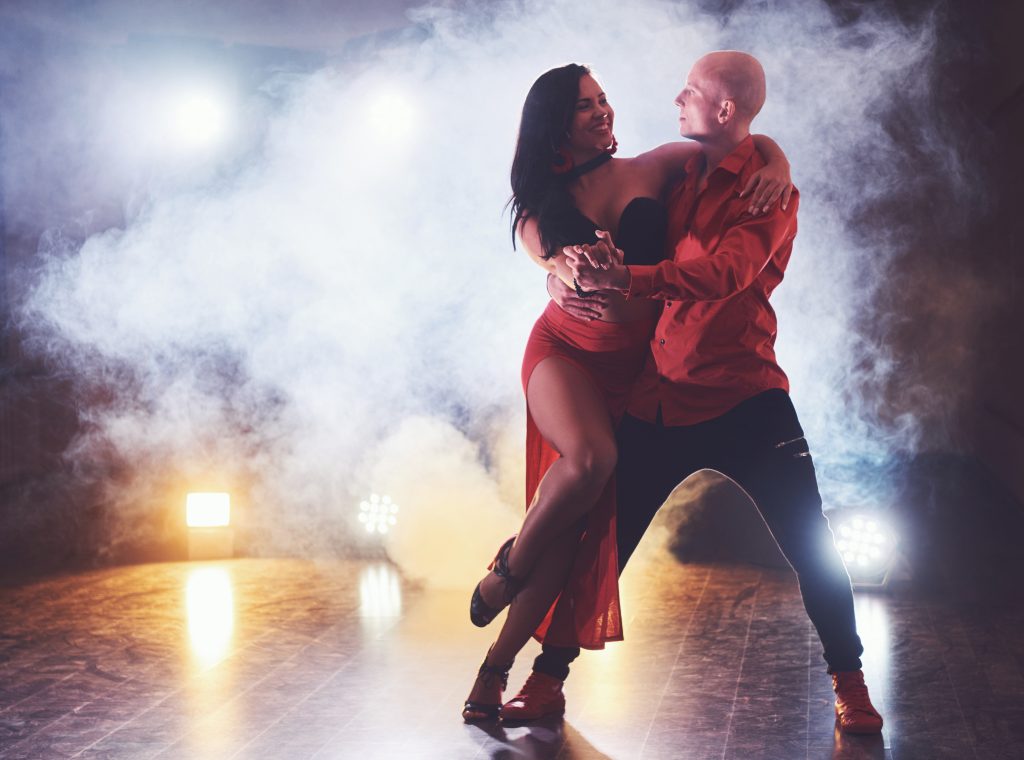 La Fiesta Dance Factory Fun Dance Classes in Sydney NSW Skillful Dancers Performing In The Dark Room Under The Concert Light And Smoke. Sensual Couple Performing An Artistic And Emotional Contemporary Dance