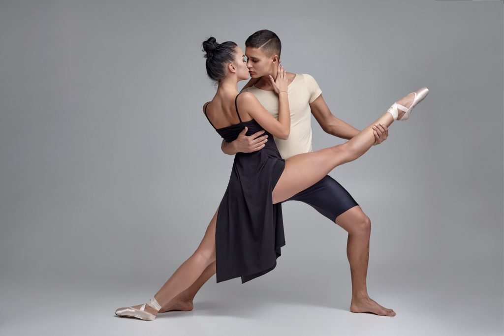 La Fiesta Dance Factory Fun Dance Classes in Sydney NSW Two Athletic Modern Ballet Dancers Are Posing Against A Gray Studio Background.